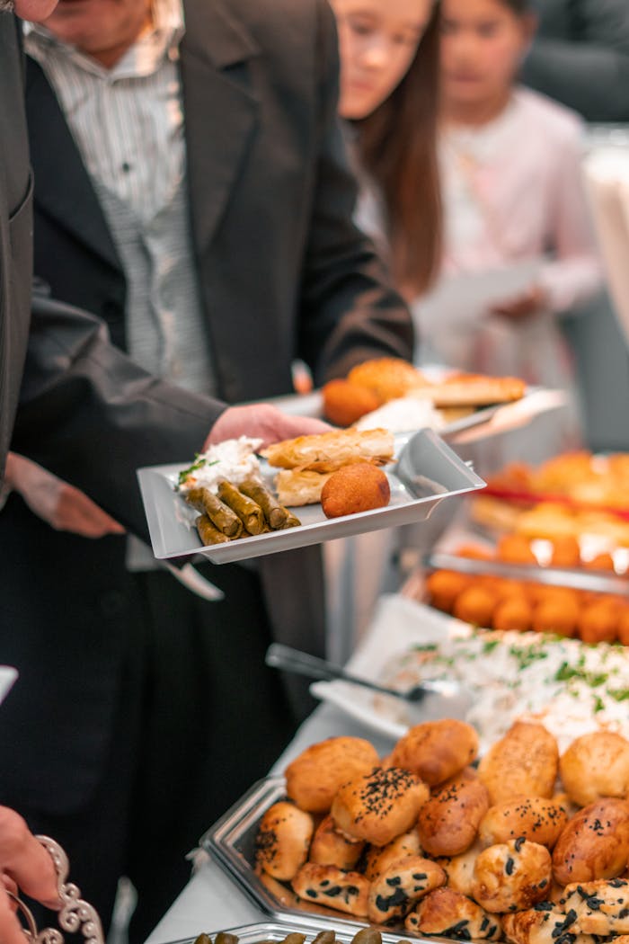 The Art of Drawing Readers In: Your attractive post title goes here A business event with adults enjoying a diverse buffet featuring bread, pastries, and salads.