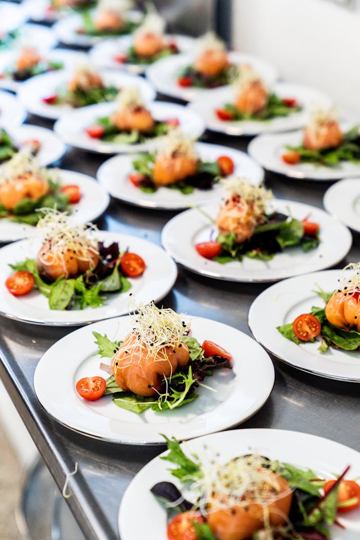Plates of gourmet sashimi salad with fresh vegetables and sprouts ready for serving.