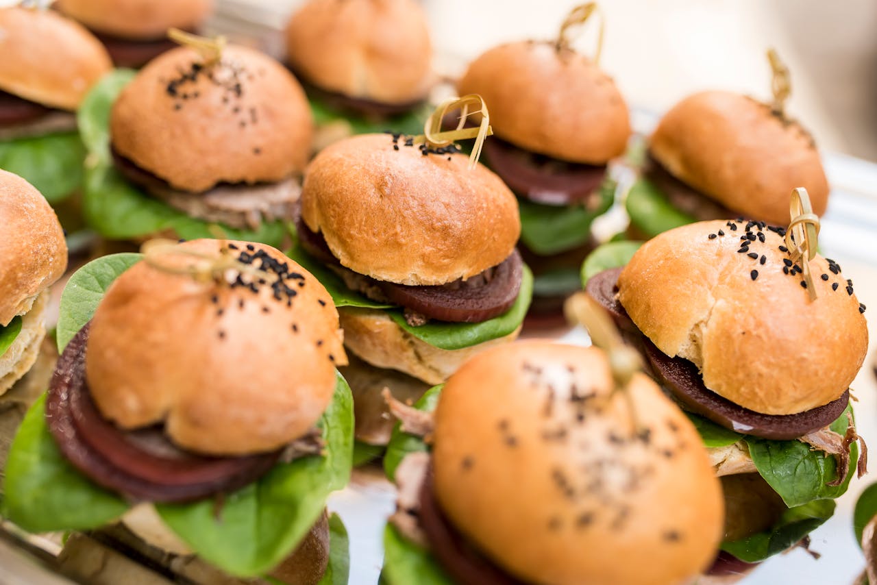 Delicious mini burgers with spinach and beetroot, perfect for parties or events, served on a decorative platter.
